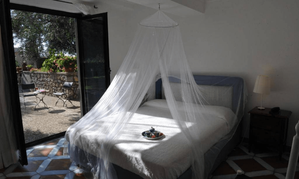 Villa Hotel Anacapri in Capri, Italy – master bedroom with vaulted ceiling and antique furnishings overlooking the sea