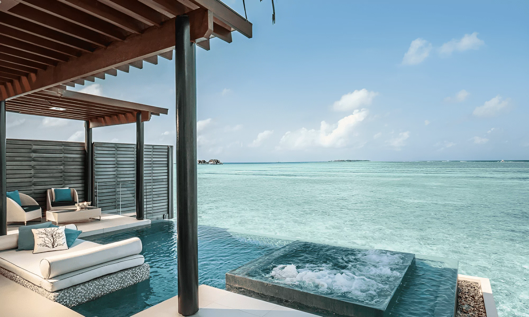 View of the ocean from the terrace of a luxury residence in the Maldives, with a pool and jacuzzi.
