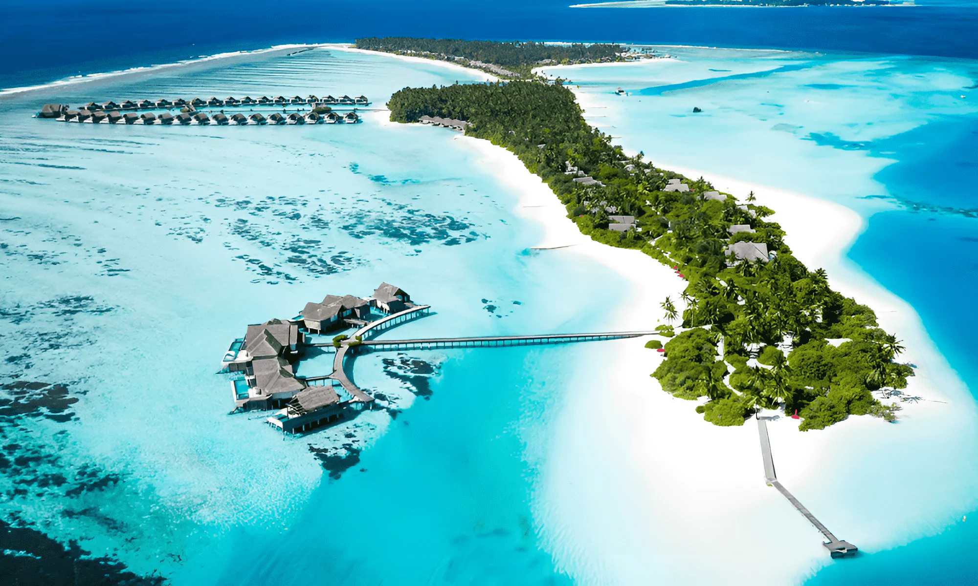 Huluwalu private island in the Maldives, with bungalows standing in the sea in the background.