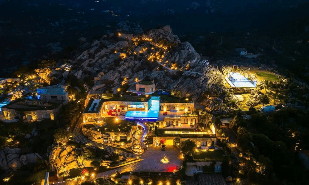 Evening exterior view of villa illuminated by warm lights