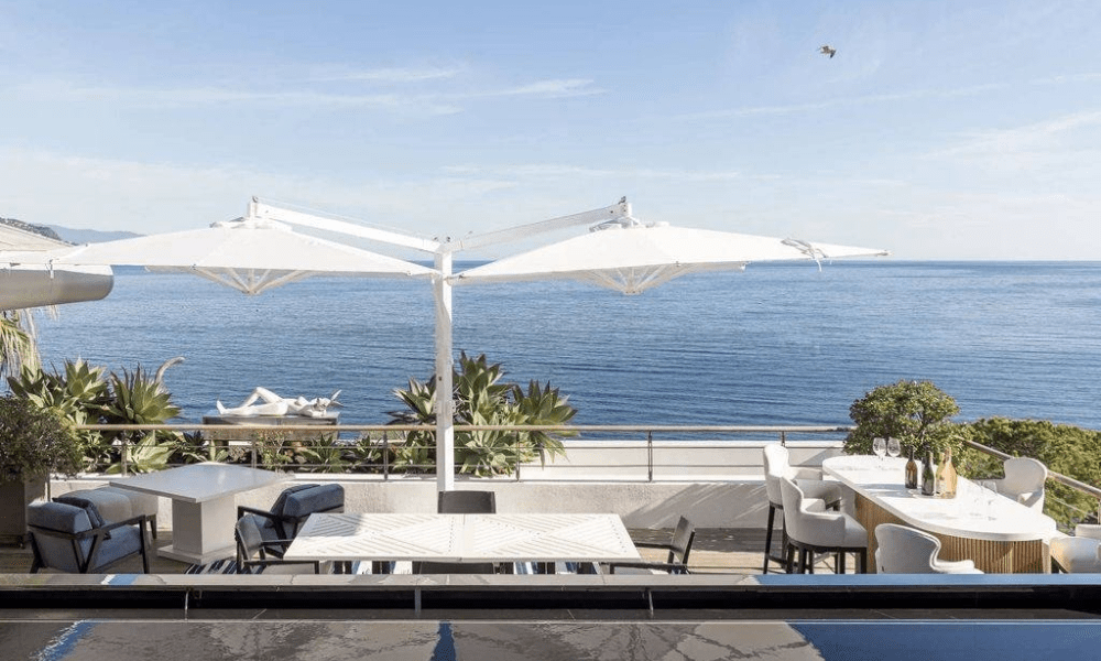 Garden seating area under trees overlooking sea
