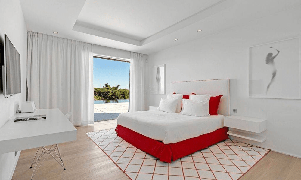 Luxury suite featuring a spacious double bed with elegant bedding, soft lighting, and modern interior design.
