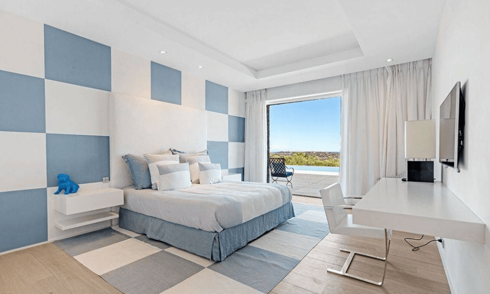 Elegant suite with a double bed and a private terrace, offering a stylish interior and outdoor seating with scenic views.