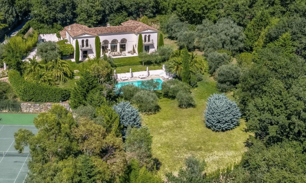 Wide-angle shot of villa façade and surrounding greenery