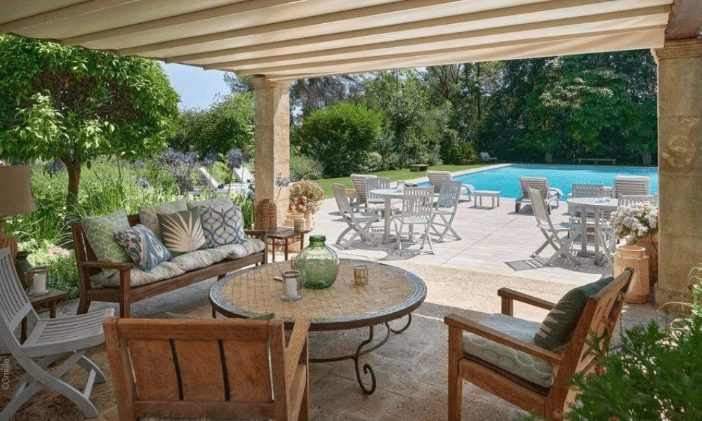Poolside sunbeds beside crystal-clear water with scenic backdrop