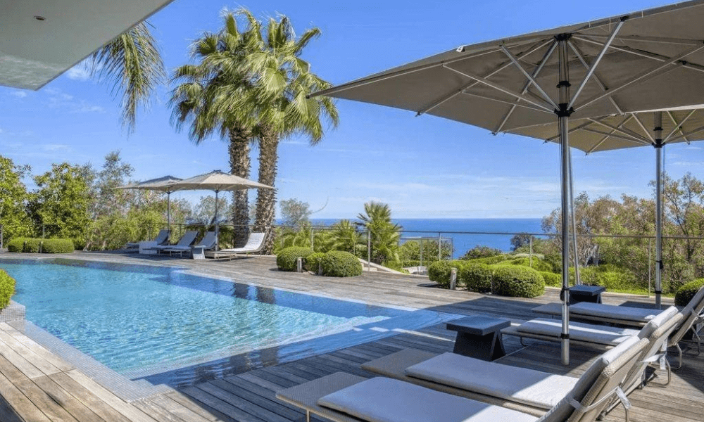 Infinity pool bordered by garden and panoramic views