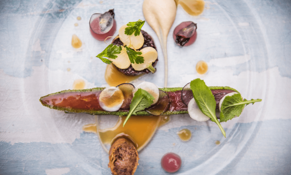 Herb-crusted tuna loin with mustard mousse, pickled grapes, microgreens, and a delicate sauce swirl